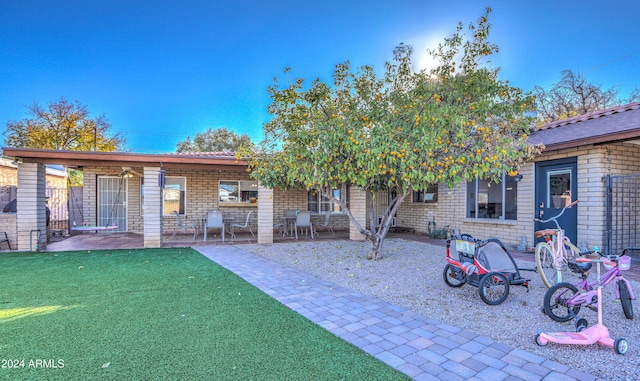 rear view of house with a yard and a patio