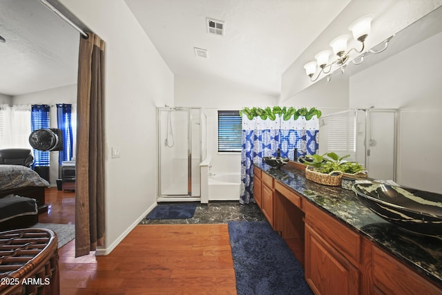 13160 W Windsor Ave, Goodyear, AZ 85395 - bathroom featuring a stall shower, lofted ceiling, a bath, wood finished floors, and plenty of natural light