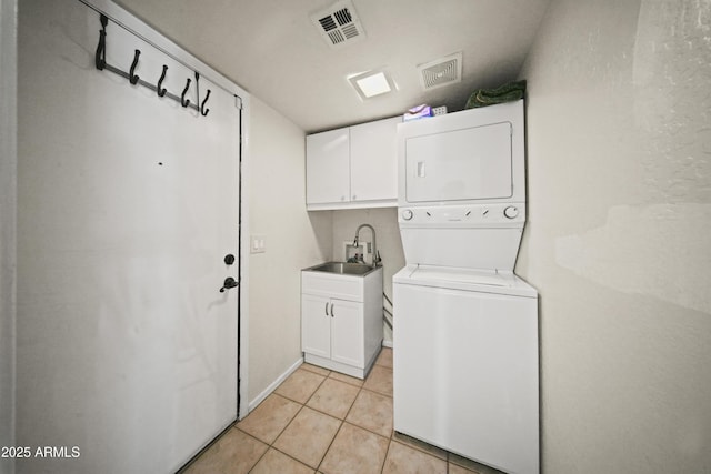 13160 W Windsor Ave, Goodyear, AZ 85395 - laundry room featuring stacked washer and clothes dryer, cabinet space, and light tile patterned flooring