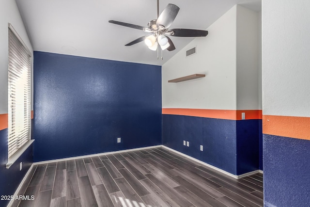 empty room featuring ceiling fan, dark wood-type flooring, and vaulted ceiling