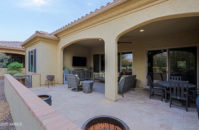 view of patio with an outdoor living space with a fire pit