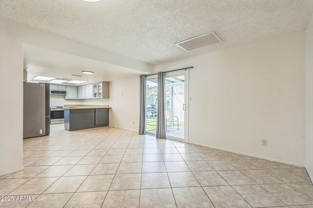3833 W Phelps Rd, Phoenix, AZ 85053 - unfurnished living room with light tile patterned floors, a textured ceiling, and baseboards