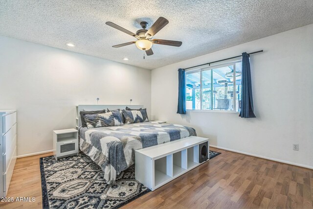 3833 W Phelps Rd, Phoenix, AZ 85053 - bedroom featuring a textured ceiling, wood finished floors, ceiling fan, baseboards, and recessed lighting