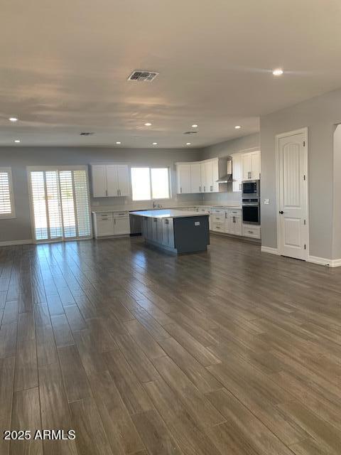 2319 N 192nd Ave, Buckeye, AZ 85396 - kitchen featuring dark wood-type flooring, white cabinetry, light countertops, and appliances with stainless steel finishes
