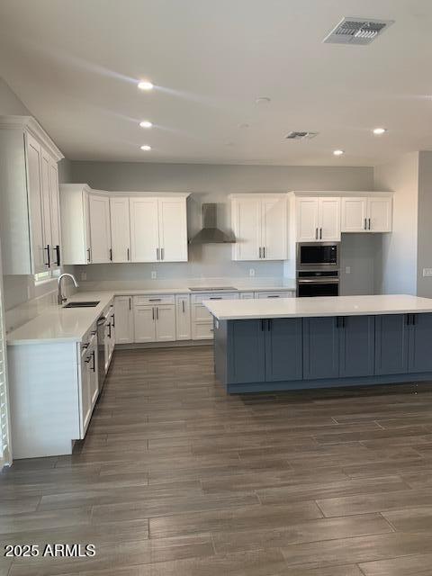2319 N 192nd Ave, Buckeye, AZ 85396 - kitchen with visible vents, wall chimney exhaust hood, a sink, and white cabinets