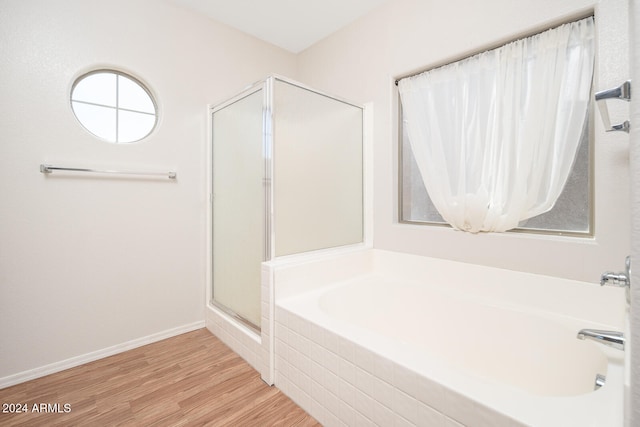 bathroom with wood-type flooring and independent shower and bath