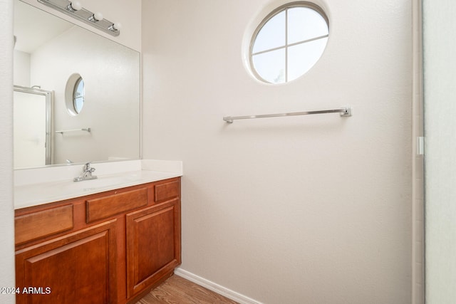 bathroom with hardwood / wood-style floors, vanity, and walk in shower