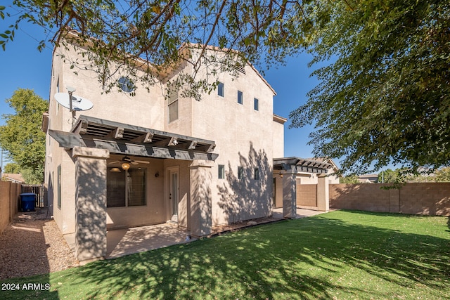 back of property featuring a lawn, ceiling fan, and a patio area