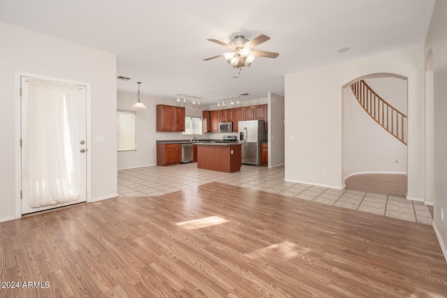 unfurnished living room featuring ceiling fan, light hardwood / wood-style flooring, and sink