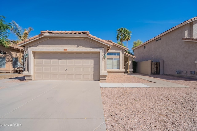 view of front of home with stucco siding, a tiled roof, concrete driveway, and a garage