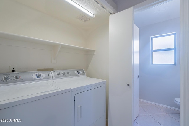 washroom with light tile patterned floors, laundry area, visible vents, and washer and dryer