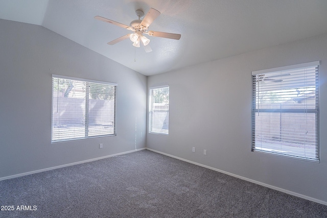 empty room with carpet floors, ceiling fan, baseboards, and vaulted ceiling