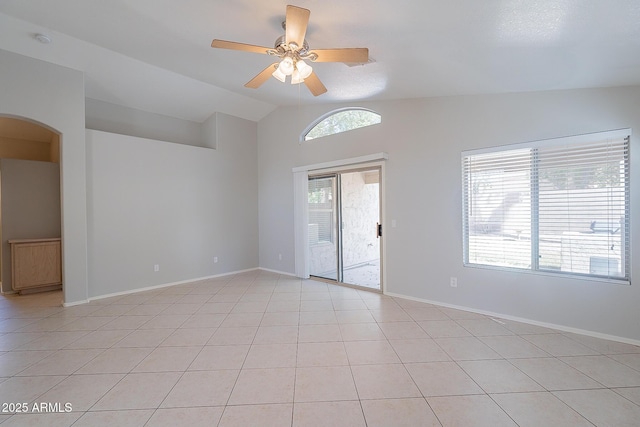 unfurnished room featuring arched walkways, ceiling fan, light tile patterned floors, lofted ceiling, and baseboards