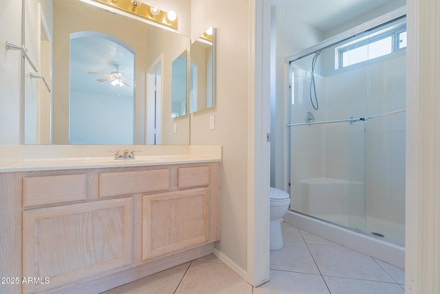 bathroom with tile patterned flooring, a shower stall, toilet, and vanity