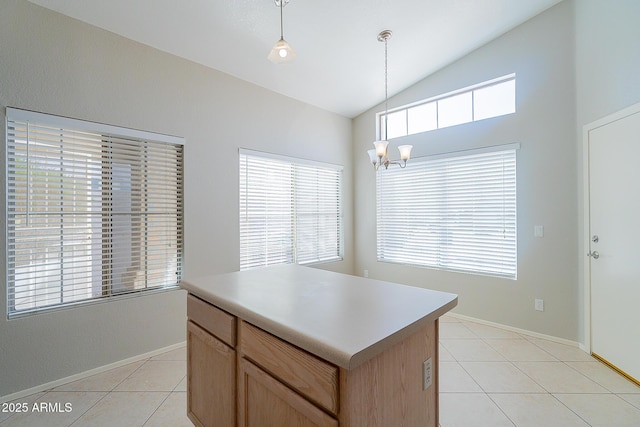 kitchen featuring pendant lighting, lofted ceiling, light brown cabinetry, light tile patterned flooring, and a chandelier