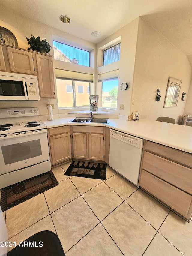 kitchen featuring sink, light tile patterned flooring, white appliances, and light brown cabinets