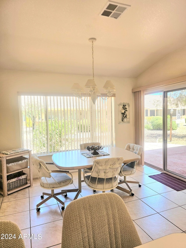 tiled dining area with a chandelier and lofted ceiling