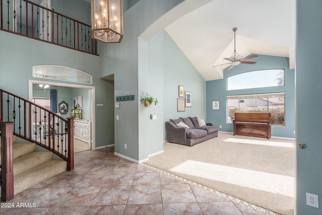 interior space with ceiling fan with notable chandelier and high vaulted ceiling