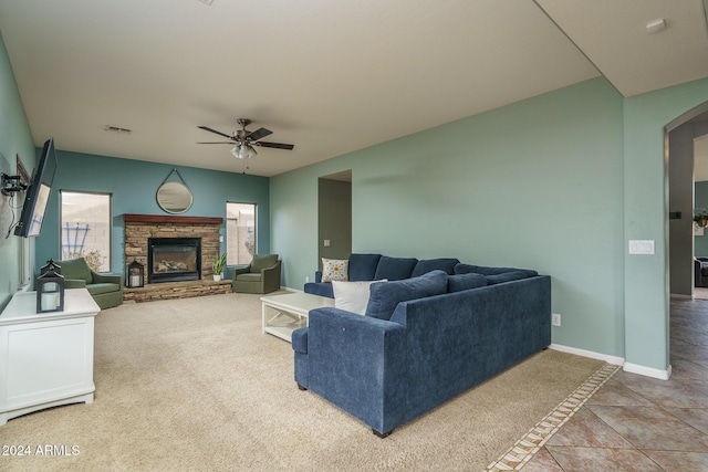 carpeted living room with ceiling fan and a fireplace