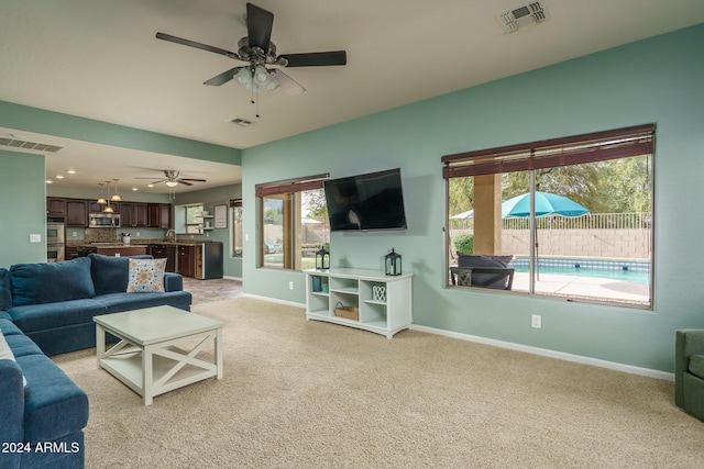 living room with ceiling fan and light colored carpet