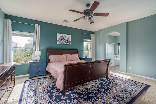 carpeted bedroom with ceiling fan and ensuite bath