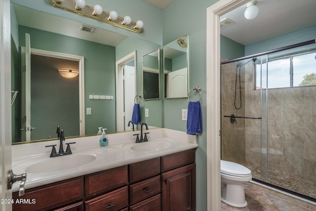 bathroom with a shower with door, vanity, and toilet