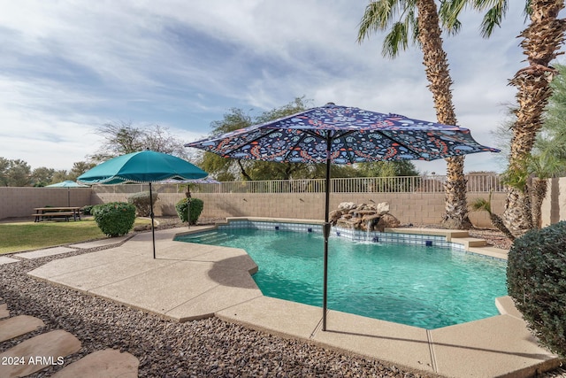 view of swimming pool featuring pool water feature and a patio