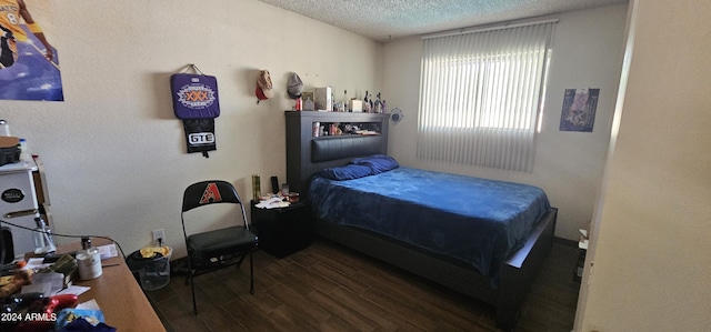 bedroom with dark hardwood / wood-style floors and a textured ceiling