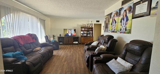 living room with wood-type flooring and a textured ceiling