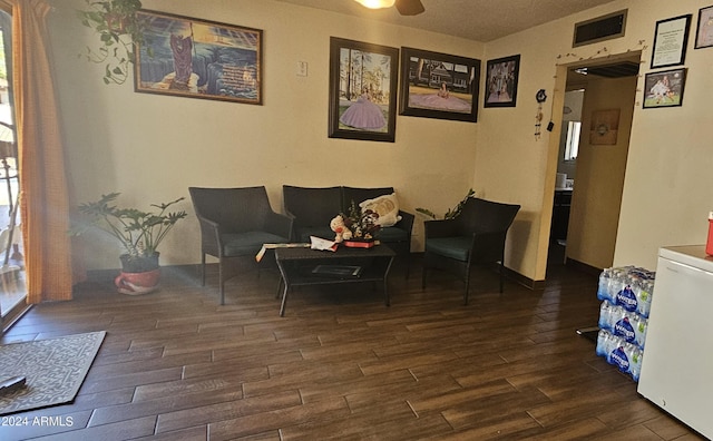 sitting room with dark hardwood / wood-style floors and ceiling fan