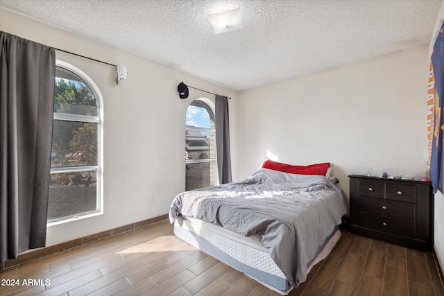 bedroom with a textured ceiling and hardwood / wood-style flooring