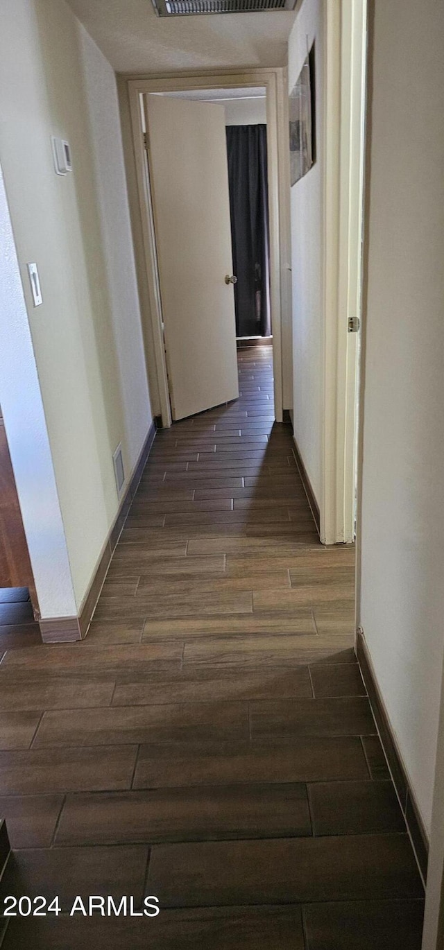 hallway with dark hardwood / wood-style flooring