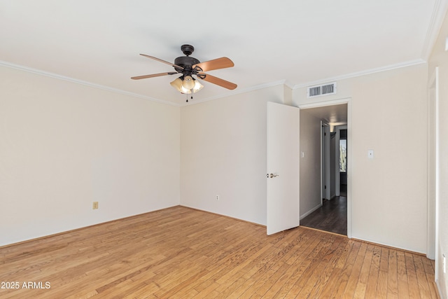 empty room featuring ceiling fan, hardwood / wood-style floors, and ornamental molding