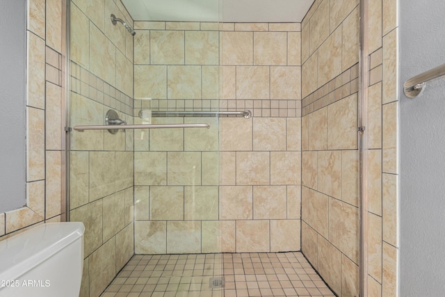 bathroom with toilet and a tile shower