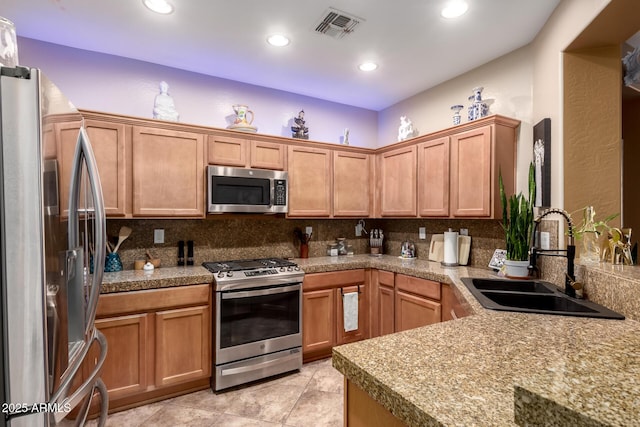 kitchen with recessed lighting, stainless steel appliances, a sink, visible vents, and tasteful backsplash