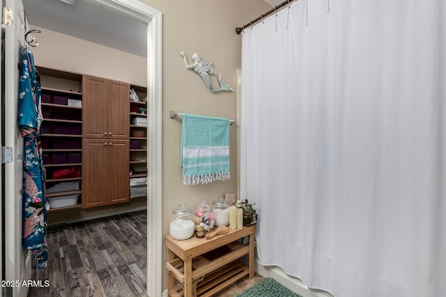 full bath with a shower with curtain and wood finished floors