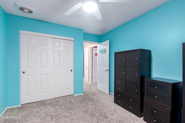 unfurnished bedroom with carpet floors, ceiling fan, visible vents, and a closet