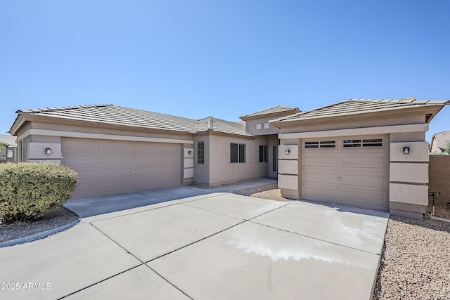 43205 W Oster Dr, Maricopa, AZ 85138 - prairie-style house with driveway, a garage, a tile roof, and stucco siding
