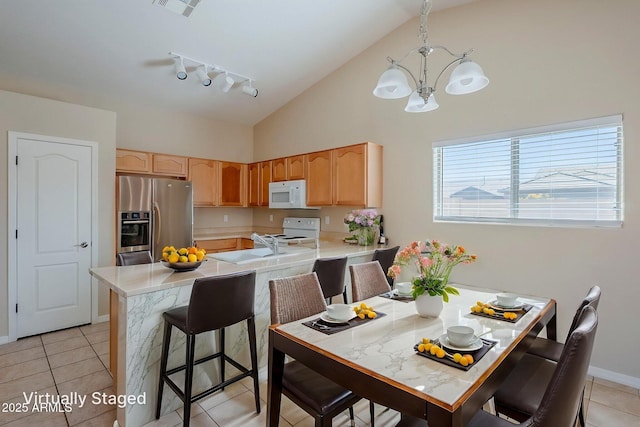 43205 W Oster Dr, Maricopa, AZ 85138 - kitchen featuring white appliances, a chandelier, light countertops, a peninsula, and high vaulted ceiling