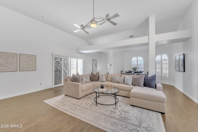 living room with ceiling fan, lofted ceiling, and light hardwood / wood-style floors