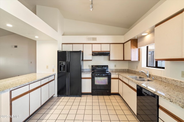 kitchen with black appliances, sink, vaulted ceiling, light stone counters, and light tile patterned floors