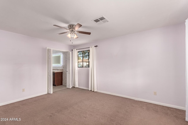 empty room featuring ceiling fan and light colored carpet