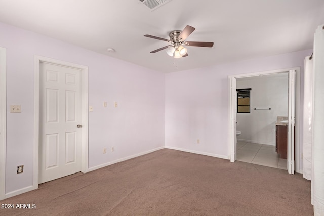 unfurnished bedroom featuring carpet, ceiling fan, and ensuite bath