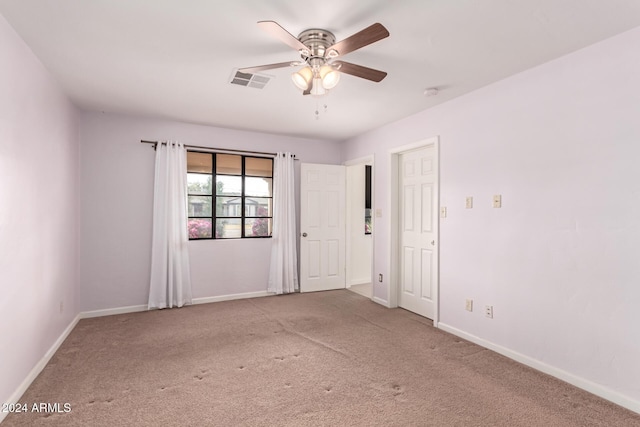 empty room featuring ceiling fan and light colored carpet