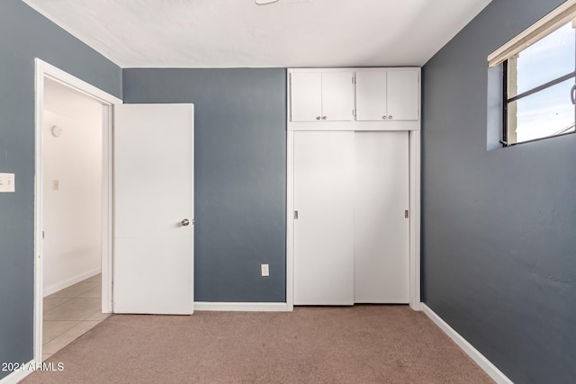 unfurnished bedroom featuring light carpet and a closet