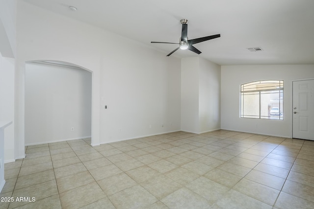 unfurnished room featuring light tile patterned floors, arched walkways, ceiling fan, and visible vents