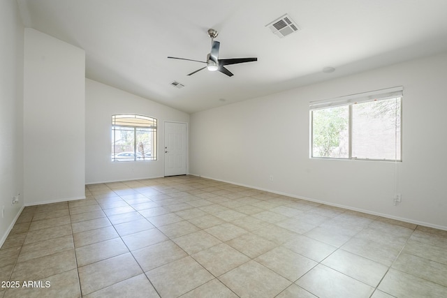 spare room with vaulted ceiling, a ceiling fan, light tile patterned flooring, and visible vents