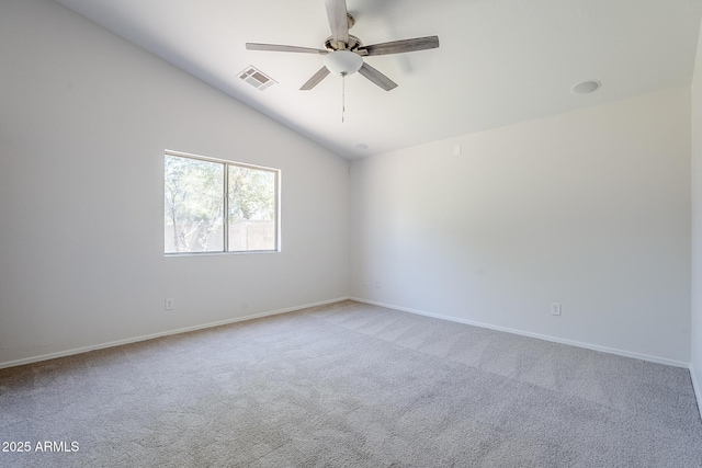 carpeted spare room with ceiling fan, visible vents, baseboards, and vaulted ceiling