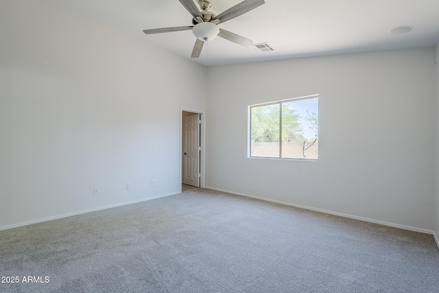carpeted empty room with baseboards, ceiling fan, and visible vents