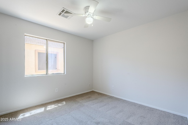 carpeted empty room with visible vents, baseboards, and ceiling fan